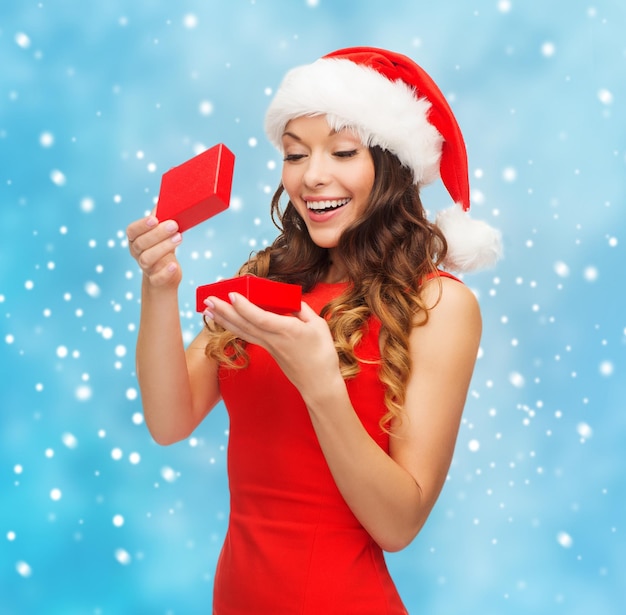 Weihnachten, Weihnachten, Winter, Glückskonzept - lächelnde Frau in Nikolausmütze mit Geschenkbox