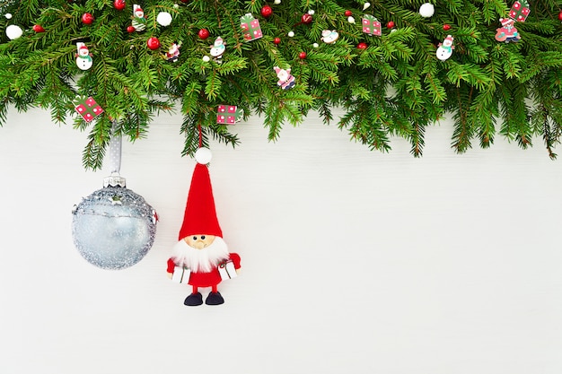 Weihnachten Weihnachtstannenbaumast mit Sankt- und Weihnachtsball auf weißem hölzernem Hintergrund. Exemplar, Ansicht von oben