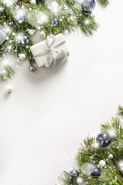 Weihnachten weißer Rahmen mit Geschenk Tanne immergrüne Zweige blaue Kugeln auf weiß