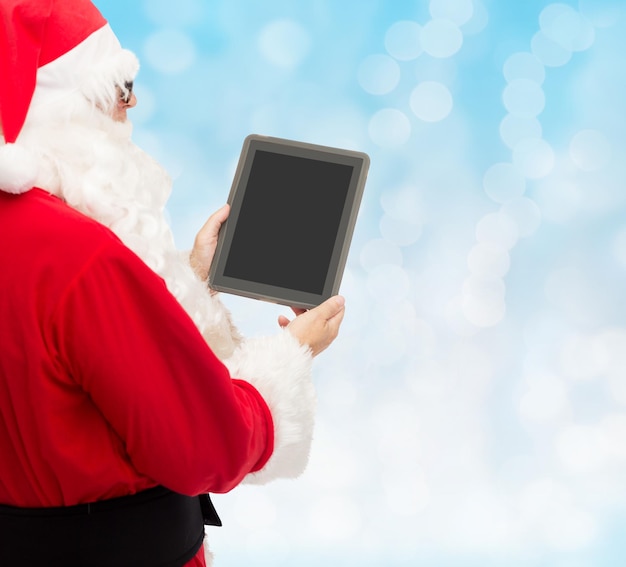 weihnachten, werbung, technologie und personenkonzept - mann im kostüm des weihnachtsmanns mit tablet-pc-computer über blaulichthintergrund