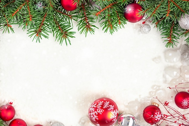 Weihnachtlicher heller Hintergrund mit Weihnachtsbaumzweigen Weihnachtsdekorationen und Schnee Schöner festlicher Hintergrund für Weihnachtsgrußkarte