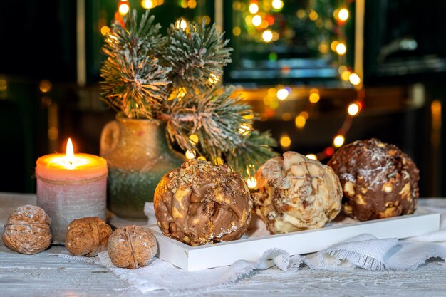 Foto weihnachtliches deutsches dessert schneeballen vor einem kamin mit lichtern auf dunklem hintergrund