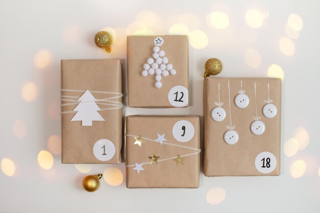 Weihnachts-Adventskalender Geschenkboxen mit Zahlen auf hellem Hintergrund mit Bokeh-DIY-Konzept