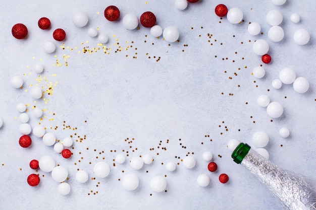 Weihnachts-Champagnerflasche mit weißen Streuseln auf Weiß.