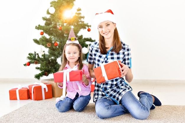 Weihnachts-, Familien- und Urlaubskonzept - Festliche Mutter und Tochter auf der Couch zu Hause im Wohnzimmer