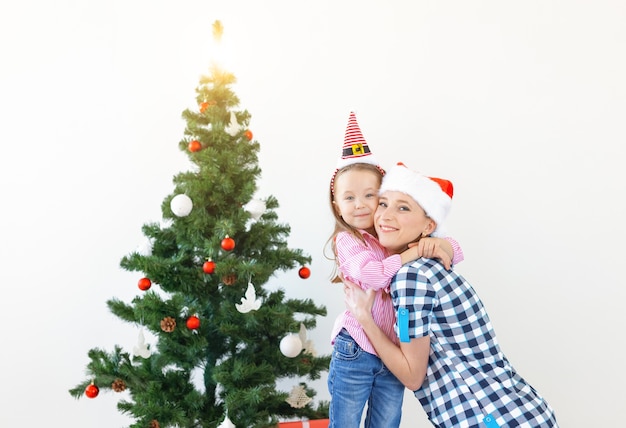 Weihnachts-, Familien- und Urlaubskonzept - Festliche Mutter und Tochter auf der Couch zu Hause im Wohnzimmer