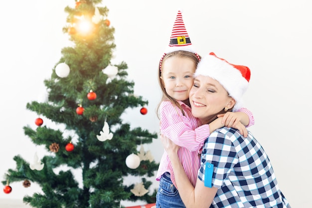 Weihnachts-, Familien- und Urlaubskonzept - Festliche Mutter und Tochter auf der Couch zu Hause im Wohnzimmer