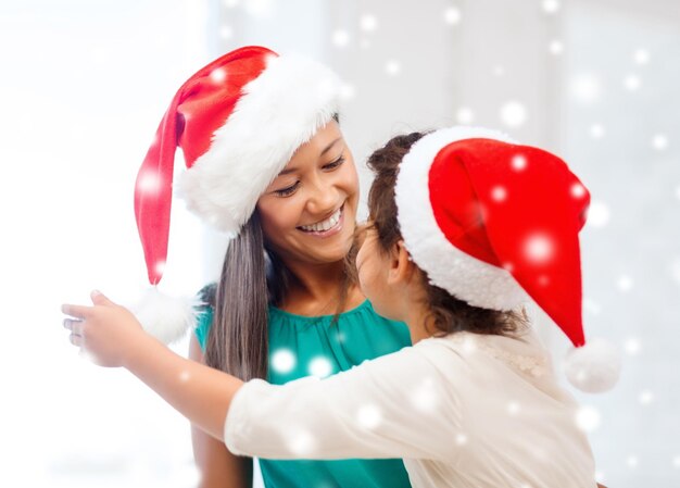 weihnachts-, feiertags-, familien- und menschenkonzept - glückliches mutter- und kindmädchen mit geschenkbox zu hause