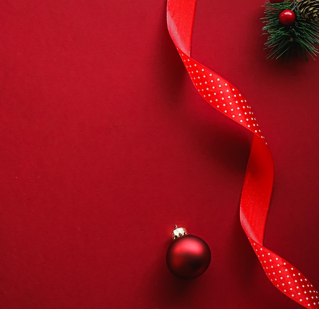 Weihnachts-Flatlay- und Urlaubsdesign-Konzept-Dekorationsverzierung und Weihnachtsgeschenkverpackung auf rotem Papier...
