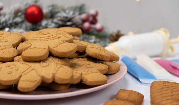 Foto weihnachts-gingerbread in form von männern und ein satz farbiger zuckerglasur zur dekoration