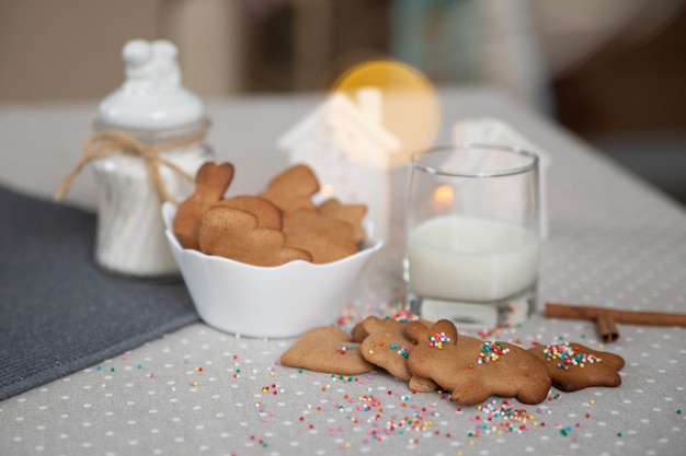 Weihnachts-Ingwerkekse mit Milch auf einem hellen Tisch