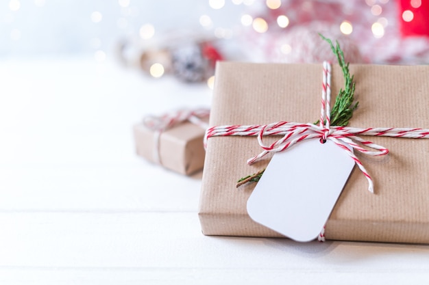 Weihnachts-Öko-Geschenk mit leerem Etikett und leuchtendem Schneebokeh.