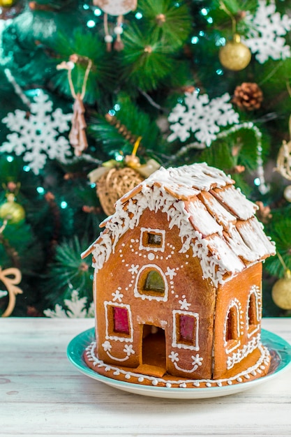 Weihnachts-Lebkuchenhaus mit Glasur auf Holztisch