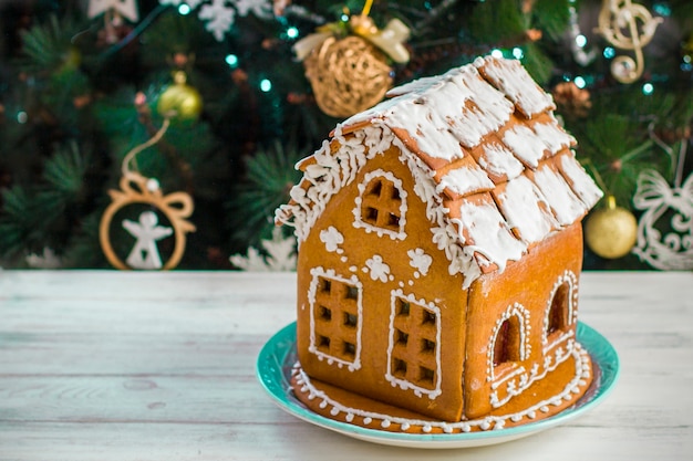 Weihnachts-Lebkuchenhaus mit Glasur auf Holztisch