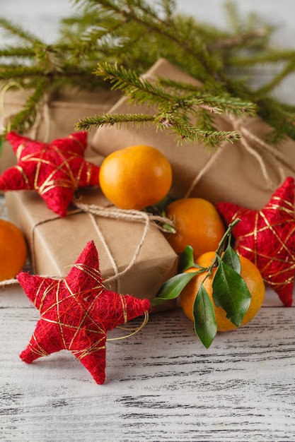 Weihnachts-Neujahrskomposition mit Tannenzweigen und orangefarbenen Mandarinen auf dem alten Holztisch im Landhausstil, selektiver Fokus