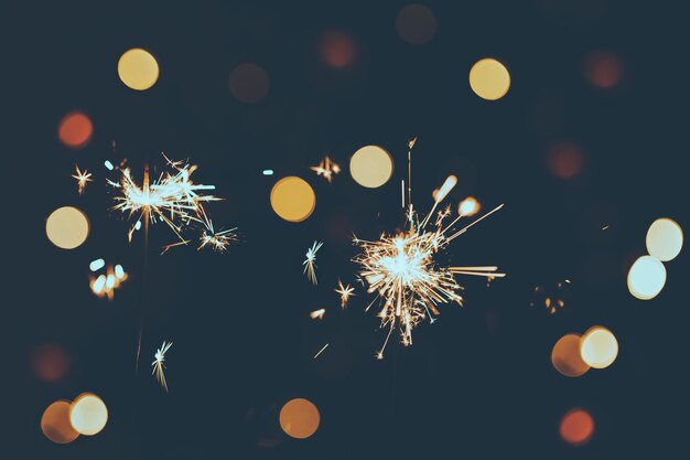 Weihnachts- oder Neujahrsfeuerwerk vor einem Hintergrund aus bunten Bokeh-Lichtern mit reduzierten Tönen