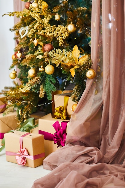 Weihnachts- und des neuen Jahresbaum verziert mit goldenen Spielwaren. Urlaub eingerichtetes Zimmer