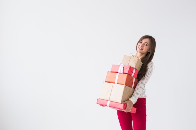 Weihnachts- und Feiertagskonzept - junge Frau, die Stapel Geschenkboxen über weißem Hintergrund mit Kopienraum hält