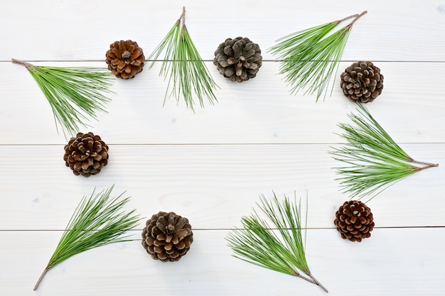 Weihnachts- und Neujahrsbaumkegel und Zweige auf einem weißen Holz