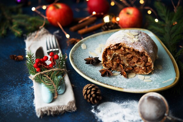 Weihnachts- und Neujahrsdessert. Apfelstrudel mit Weihnachtsbeleuchtung.