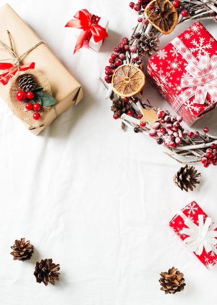 Weihnachts- und Neujahrsflachlagedekor mit Kranz und Geschenkbox auf Draufsichtkopienraum des weißen Hintergrundes