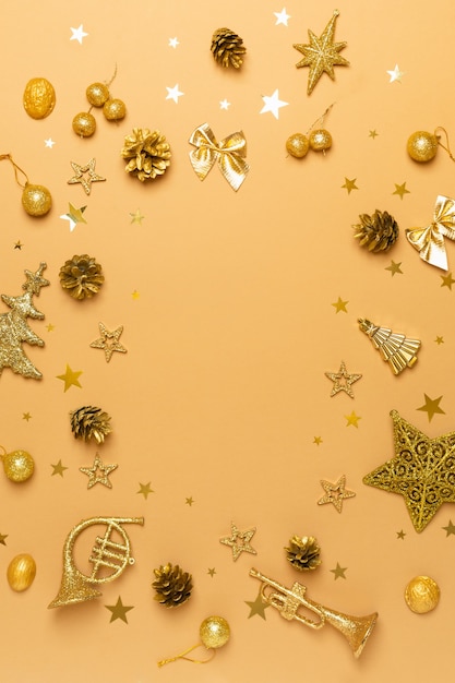 Weihnachts- und Neujahrskomposition flach mit goldenen Dekorationen auf Beige