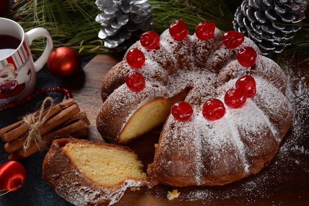 Weihnachts- und Neujahrskonzept Köstlicher Zitronenkuchen mit roten Süßkirschen und Zuckerpulver