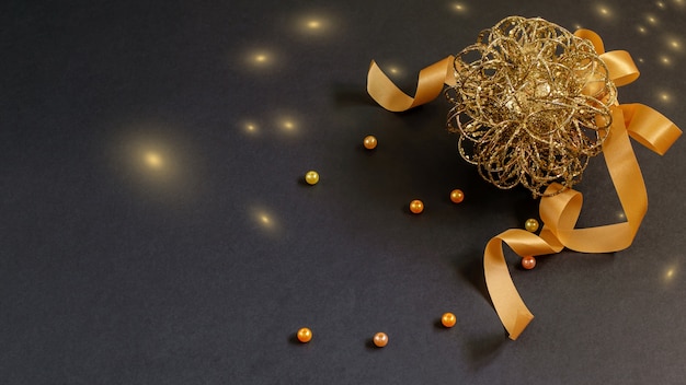 Weihnachts- und Neujahrskugel mit Band und Perlen auf dem Schwarz.