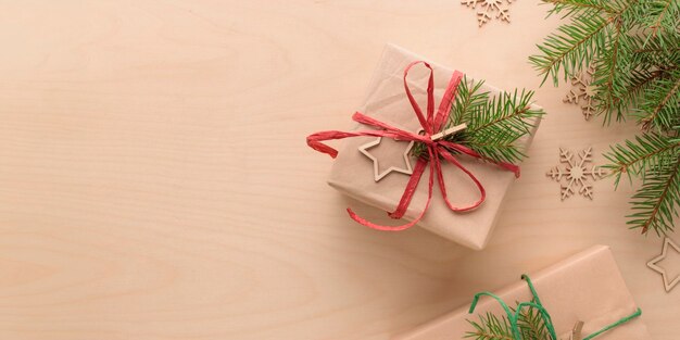 Weihnachts- und Umweltfreundliche natürliche Verpackung Geschenk in Handwerkspapier auf einem Holztisch Öko-Weihnachtsferienkonzept Öko-Dekorationsbanner