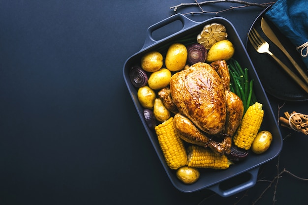 Weihnachtsabendessentisch mit Huhn auf Dunkelheit