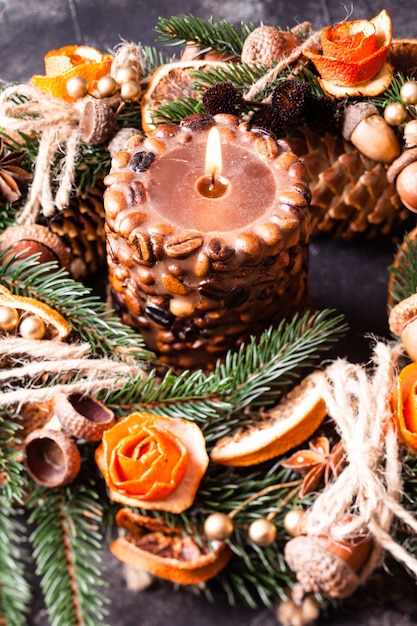 Weihnachtsaromatischer Öko-Kranz verzierte Mandarinenschalenrosen mit brennender Kaffeekerze