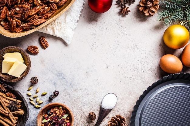 Weihnachtsbäckerei Hintergrund. Bestandteile für die Feiertagstorte auf einem grauen Hintergrund, Draufsicht, Kopienraum.