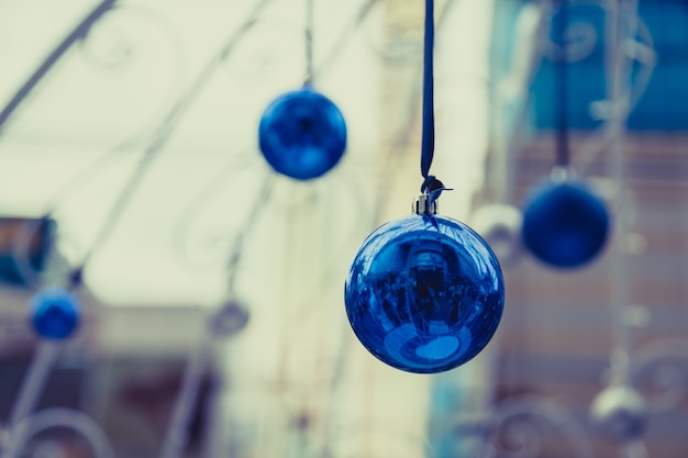 Weihnachtsbälle, die am Band mit bokeh Hintergrund hängen