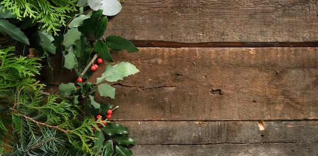 Weihnachtsbanner Frische Fichtenzweige und Holly auf Holzhintergrund kopieren Raum