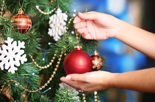 Weihnachtsbaum auf hellem Hintergrund schmücken