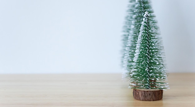 Weihnachtsbaum auf Holztisch mit weißem Wandhintergrund