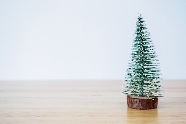 Weihnachtsbaum auf Holztisch mit weißem Wandhintergrund