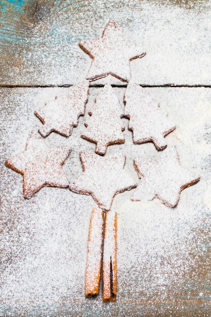 Foto weihnachtsbaum aus lebkuchen auf holzhintergrund mit kopienraum für text. urlaub, feier und kochkonzept. neujahrs- und weihnachtspostkarte.