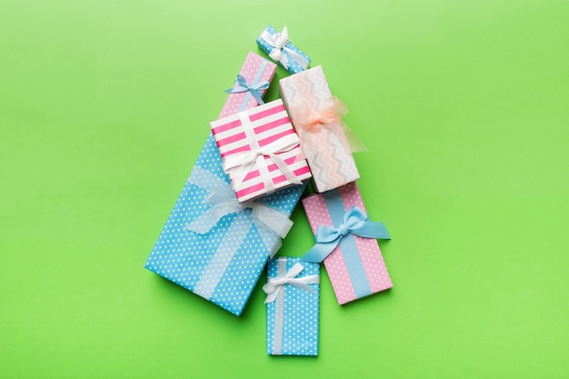 Weihnachtsbaum aus wunderschön verpackten Geschenken auf farbigem Hintergrund, Ansicht von oben. Neujahrsgeschenkbox minimales Konzept mit Kopienraum
