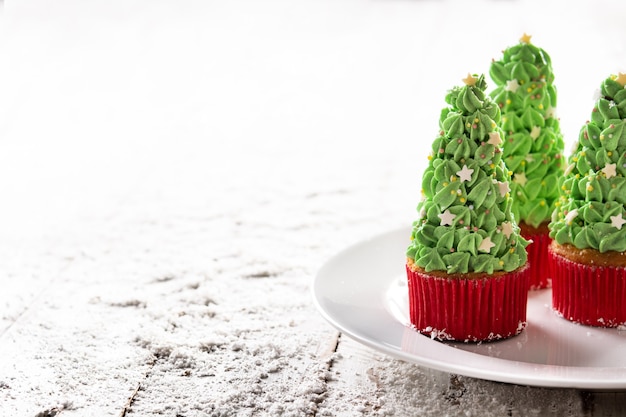 Foto weihnachtsbaum-cupcakes auf schnee