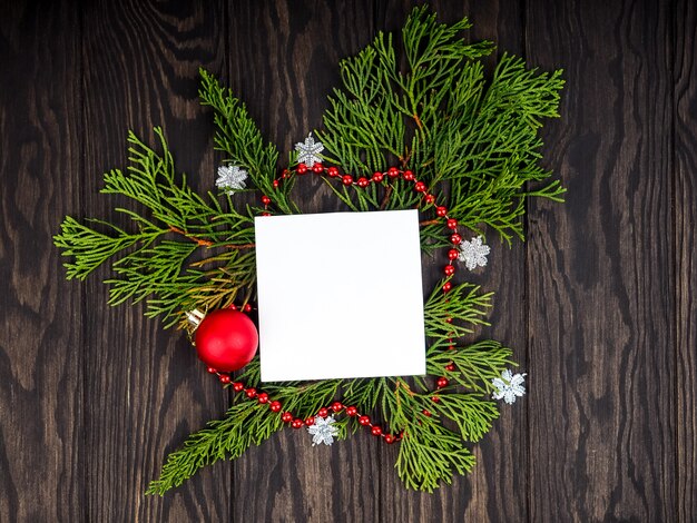 Weihnachtsbaum-Hintergründe, kreativer Plan gemacht von den Weihnachtsbaumasten mit Schnee- und Papierkartenanmerkung. Flach liegen. Natur-Neujahrskonzept.