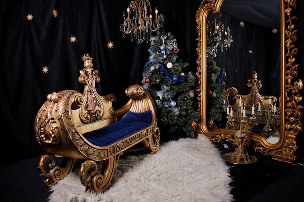 Weihnachtsbaum im dunklen Innenraum mit antiken Möbeln und großem Spiegel
