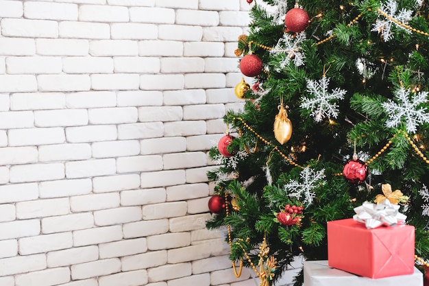 Weihnachtsbaum im Grün mit rotem Dekor im Raum.