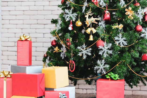 Weihnachtsbaum im Grün mit rotem Dekor im Raum.