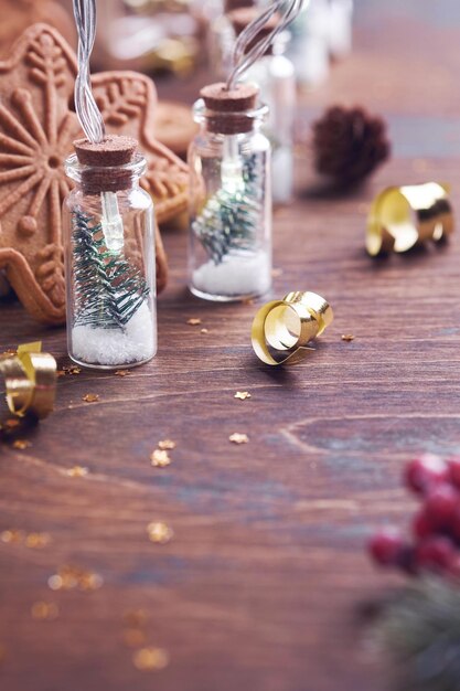 Weihnachtsbaum in Glasgirlandendekoration, Weihnachtstannenbaumzweigen und Weihnachtslebkuchen auf altem hölzernem Hintergrund. Selektiver Fokus, Kopienraum. Frohe Weihnachten und ein glückliches neues Jahr-Konzept