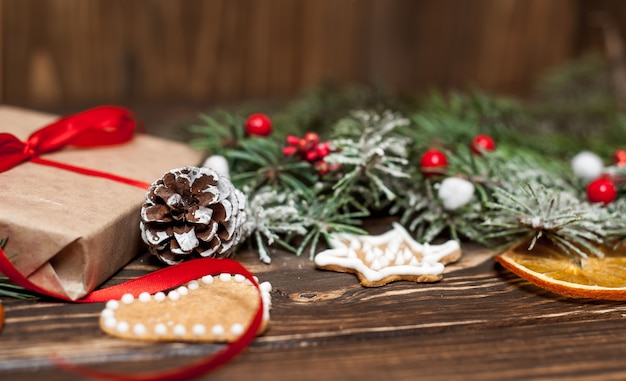 Weihnachtsbaum mit Dekorationen auf einem Holzbrett und Geschenken. Kopieren Sie Platz für Text