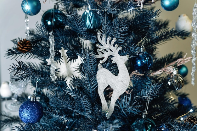 Weihnachtsbaum mit einer Hirschfigur, die daran hängt