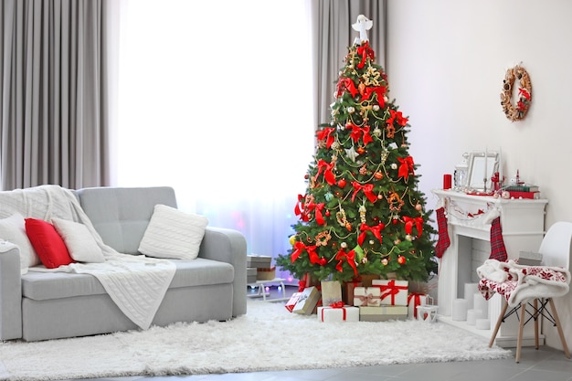 Weihnachtsbaum mit Geschenken darunter im Wohnzimmer