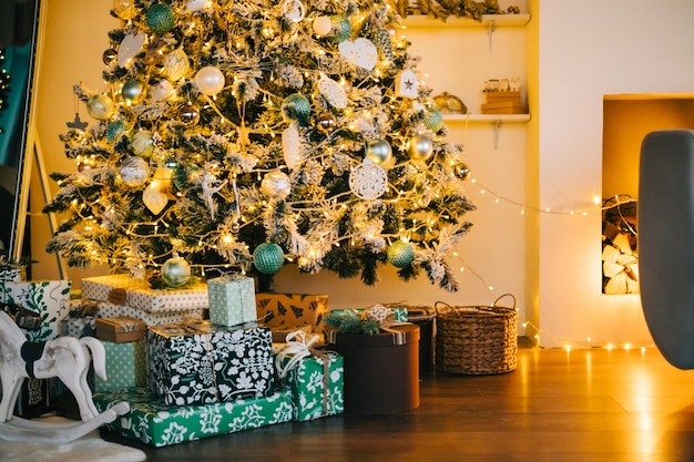 Foto weihnachtsbaum mit geschenken im wohnzimmer am abend.