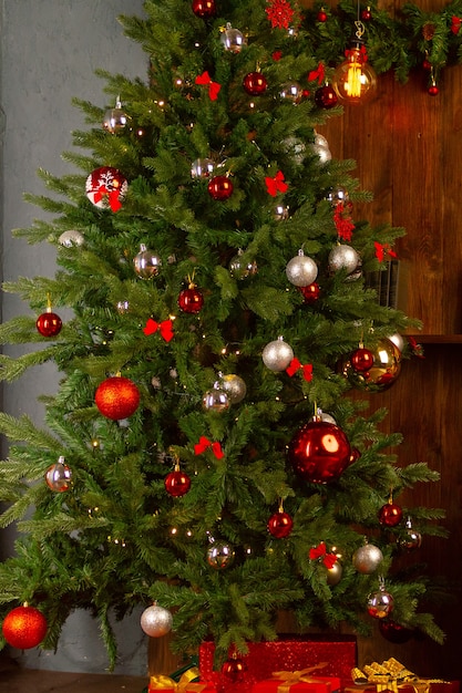 Weihnachtsbaum mit Girlande auf dem Hintergrund einer Holzwand